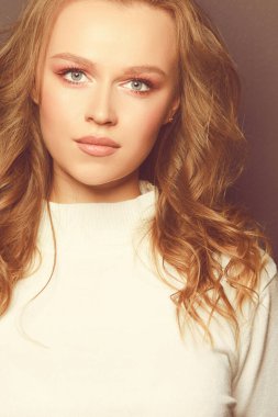 Güzel kadın taze günlük makyaj ve romantik dalgalı saç modeliyle portresi.