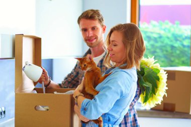 Genç bir çift yeni evde büyük karton kutu taşıyan. Ev taşıma. Genç Çift.