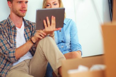 Genç bir çift yeni ev içinde hareket. Oturma ve açma sonra rahatlatıcı. Bir şey üstünde laptop arıyorum. Genç Çift.