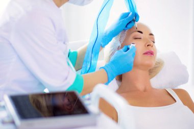 Kaşlar için kalıcı makyaj. Güzellik salonunda kalın kaşlı güzel bir kadın..