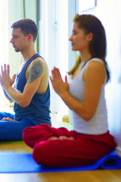 年轻健康的夫妇 在白色背景上的瑜伽位置 — 图库照片