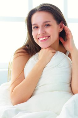 Güzel bir kadın yatağında uzanıyor..