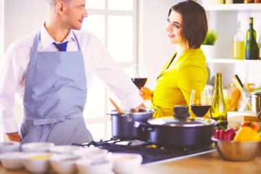 Aşık çekici bir çift yemek pişirir ve onlar romantik bir akşam yemeği pişirirken mutfakta şarap açar..