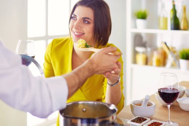 Evdeki mutfakta birlikte yemek pişiren çift..