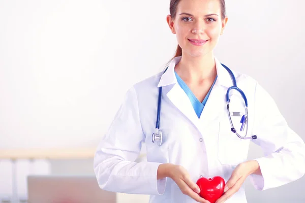 Masada Oturan Kalp Tutan Güzel Genç Gülümseyen Kadın Doktor — Stok fotoğraf