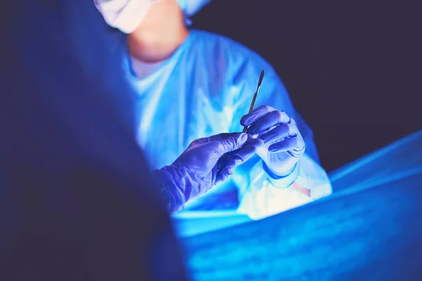在黑暗背景下做手术的医生 — 图库照片