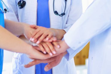 Bir grup doktor ellerini birleştiriyor.