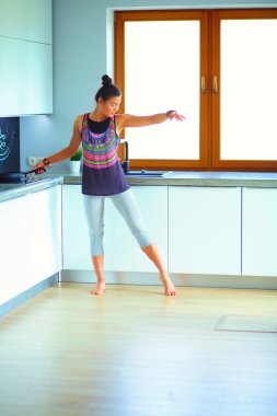 Formda ve çekici genç bir kadın sağlıklı yemek hazırlıyor. Kadın