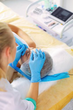 Kaşlar için kalıcı makyaj. Güzellik salonunda kalın kaşlı güzel bir kadın.