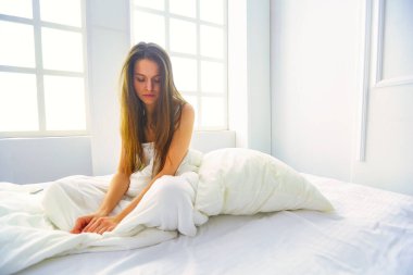 Genç kadın duygu ağrı yatakta