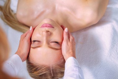 Masaj masasında uzanmış gözleri kapalı rahatlayan genç bir kadın. - Kadın. Spa salonu.