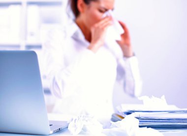 Üzgün genç portresi hasta kadın ofiste oturan ve bir burun peçete ile silinerek.