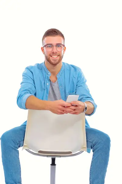 若い男の椅子に座って 携帯電話を使用しています Startupper 若い起業家 — ストック写真