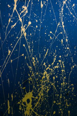Abstract yellow paint splashes, element of creative graffiti on a bright blue background.
