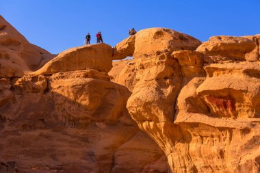 Ürdün, Wadi Rum - 2 Kasım 2022: Ünlü Ümmü Frouth doğal taş köprü kemeri ve çöl manzaralı turistler