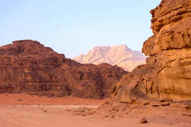Wadi Rum, Jordan. Turuncu kum çölü manzarası ve şafak vakti Jabal Al Qattar dağları, gün batımı.