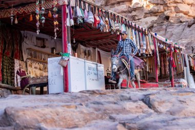 Petra, Ürdün - 3 Kasım 2022 Ünlü antik şehirde atlıyla yolda yürüyen eşek