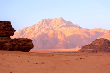Wadi Rum, Jordan. Turuncu kum çölü manzarası ve şafak vakti Jabal Al Qattar dağları, gün batımı.