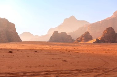 Wadi Rum, Jordan. Turuncu kum çölü manzarası ve şafak vakti Jabal Al Qattar dağları, gün batımı.