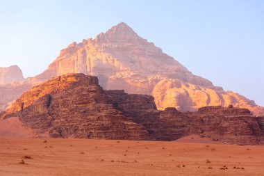 Wadi Rum, Jordan. Turuncu kum çölü manzarası ve şafak vakti Jabal Al Qattar dağları, gün batımı.