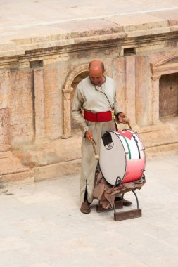 Jerash, Jordan - November 7, 2022: Jordanian drum player in the roman theatre of the archeological site
