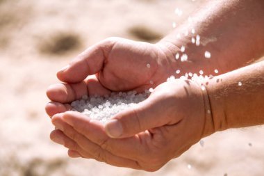Dead Sea salt crystals in man hands, natural minerals for health