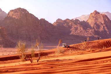 Jordan, Wadi Rum - November 2, 2022: Jeep safari in desert. Tourists and off-road car traces on dune sand and the beautiful rocks landscape