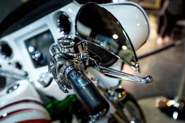 Black classic motorcycle handlebar and chrome mirror close-up selective focus
