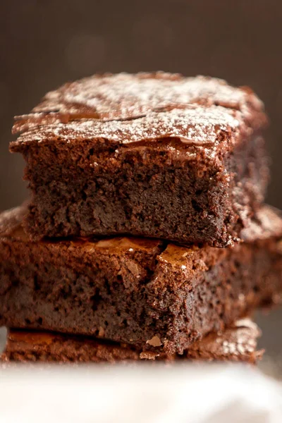 Homemade dark chocolate fudge brownies cake stacked on stone plate close-up