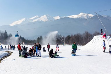 Bansko, Bulgaria - February 11, 2023: Bulgarian winter ski resort panorama with gondola lift cabins, Pirin mountain peaks view and slope