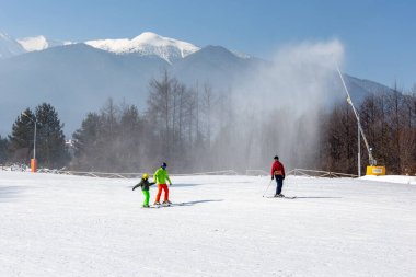 Bansko, Bulgaria - February 11, 2023: Bulgarian winter ski resort panorama with gondola lift cabins, Pirin mountain peaks view and slope