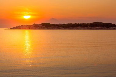 Mount Athos in Greece at sunset, bright sunrise in the early summer morning, orange sun, background