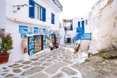 Mikonos, Yunanistan - 23 Nisan 2019: Kiklad Adaları'nda beyaz evler ve hediyelik eşya dükkanı ile ünlü ada sokak manzarası