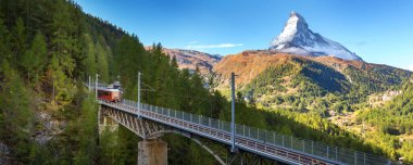 Zermatt, İsviçre. Köprüde Gornergrat kırmızı turist treni ve İsviçre Alplerinde Matterhorn zirvesi panoraması, benner