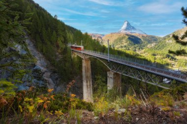 Zermatt, İsviçre. Köprüde Gornergrat kırmızı turist treni ve İsviçre Alplerinde Matterhorn zirvesi manzarası
