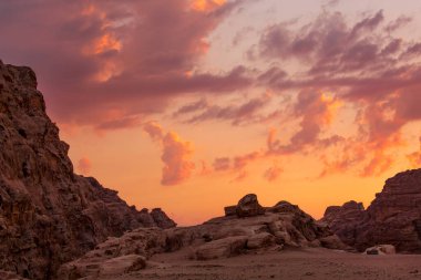 Küçük Petra arkeoloji sahasında kumtaşı kayaları olan günbatımı turuncu gökyüzü manzarası, Ürdün