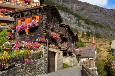 Yazın penceresinde sardunya çiçekleri olan geleneksel tahta dağ evi, Zermatt alp köyü, İsviçre, İsviçre Alpleri