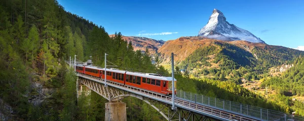 瑞士Zermatt 位于瑞士阿尔卑斯山桥和马特宏峰全景的Gornergrat红色旅游列车 图库照片