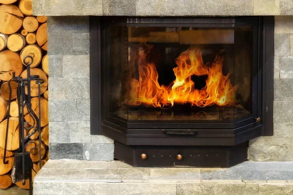 火の炎と石の暖炉 冬の素朴なスタイル居心地の良い家 ロイヤリティフリーのストック写真