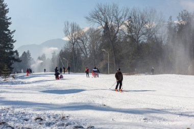 Bansko, Bulgaria - February 11, 2023: Bulgarian winter ski resort panorama with Pirin mountain peaks view and slope