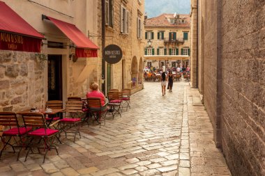 Kotor, Karadağ - 20 Eylül 2023: Kafe ve antik taş binalarla eski kentin dar sokakları