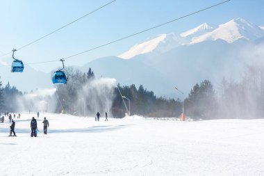 Bulgaristan 'ın Bansko kenti - 11 Şubat 2023: Bulgaristan' da Gondol kaldırma kulubeleri, Pirin dağı zirveleri manzarası ve yamaçlı kış kayak merkezi manzarası