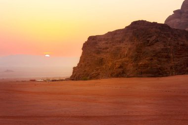 Jordan, Wadi Rum güneşi ufukta beliriyor, çölde gün doğumu, kamp çadırları.