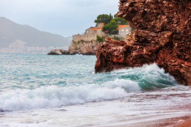 Karadağ 'ın Budva kenti yakınlarındaki Sveti Stefan adasında bir otel. Dalgalar ve kırmızı kayalar