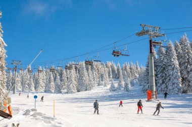 Kopaonik, Sırbistan - 22 Ocak 2016: Kayak merkezi Kopaonik, Sırbistan, kayak pisti, kayak pistindeki insanlar, dağlar, evler ve binalar panorama