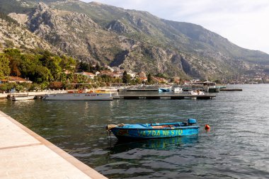 Kotor, Karadağ - 20 Eylül 2023: Çapalı tekneler, Adriyatik Denizi ve dağlarla dolu yaz manzarası