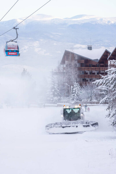 Bansko, Bulgaria - January 21, 2024: Bulgarian winter ski resort with ratrack on the slope, gondola lift cabins