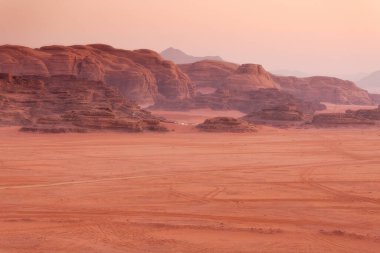Wadi Rum, Jordan. Turuncu kum çölü manzarası ve şafak vakti kaya dağları.