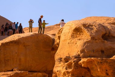 Ürdün, Wadi Rum - 2 Kasım 2022: Ünlü çöl simgesi Burdah Kaya Köprüsü ve insanlar