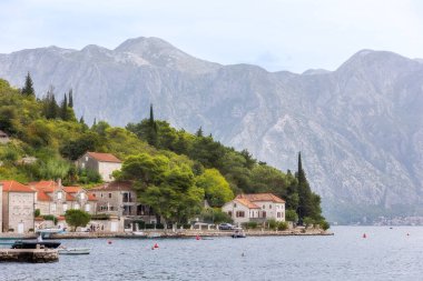 Perast, Karadağ - 21 Eylül 2023: Antik kent ve yüksek dağlardaki panorama üzerindeki evler